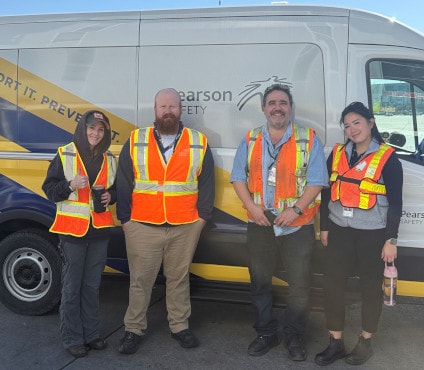 a group of people wearing safety vests posing for a photo