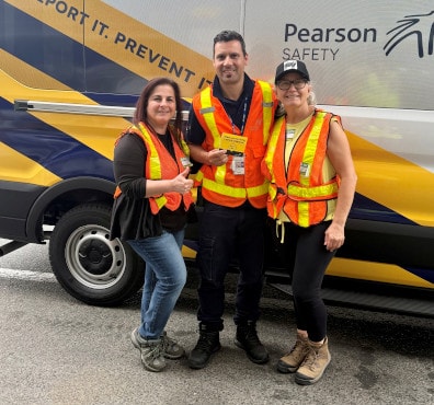 a group of people posing for a photo in front of a yellow truck