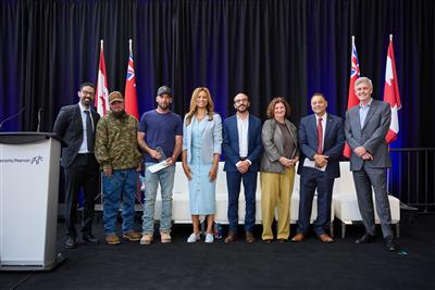 a group of people standing on a stage with flags behind them