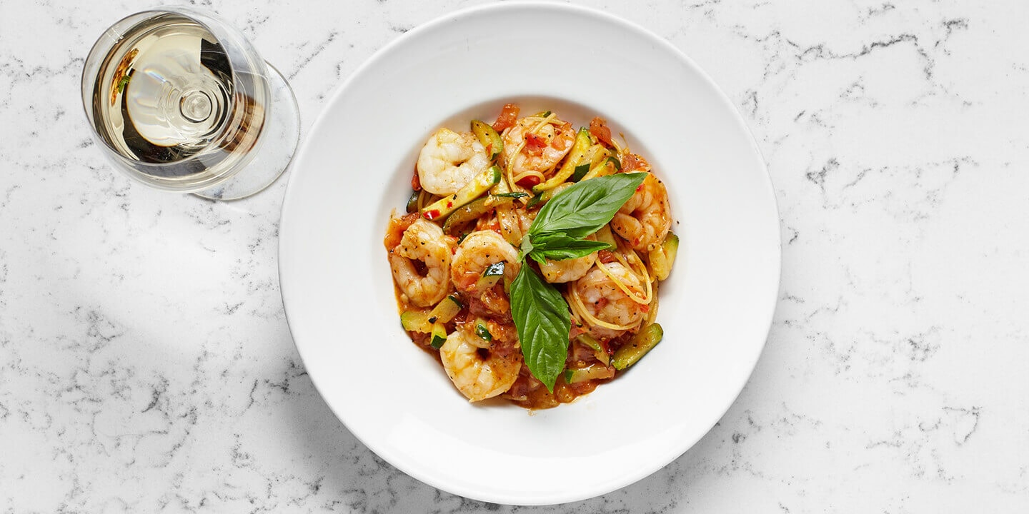 Shrimp on pasta with a glass of white wine