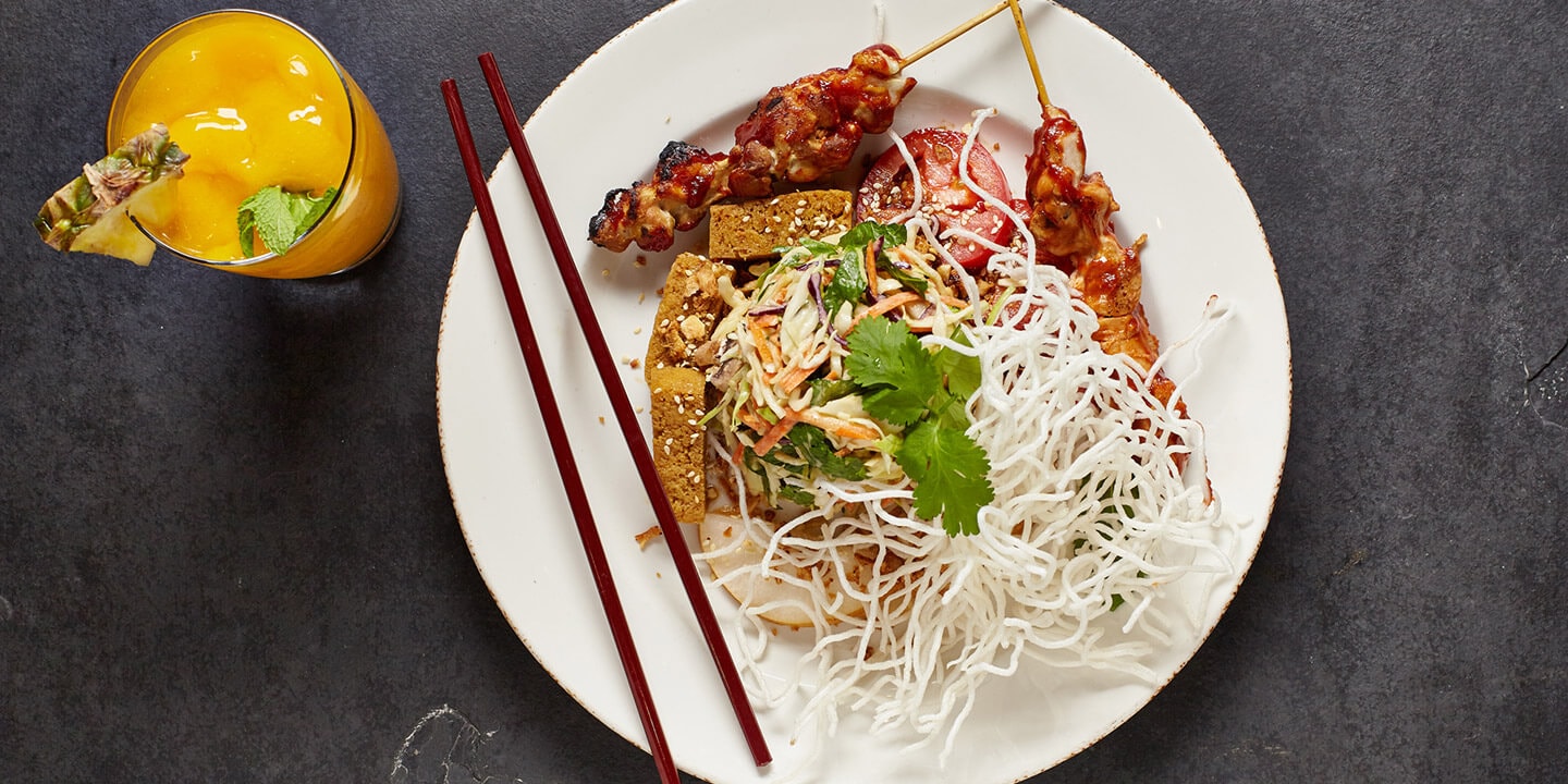 Chicken skewers with crispy rice noodles, tofu and salad