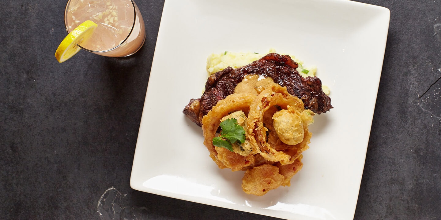 steak and a pink cocktail