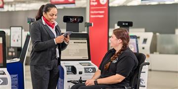 a woman showing a man something on the computer