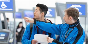 a person holding a paper and looking at another man