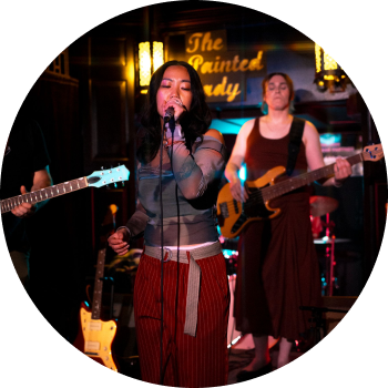 a group of women singing and playing guitars
