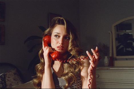 a woman holding a red object to her face