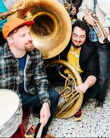 a man playing a saxophone next to a man playing a saxophone