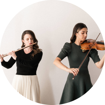 a person playing a violin next to another woman
