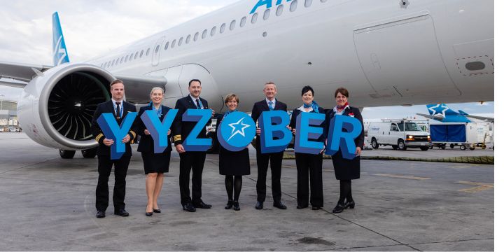 a group of people posing for a photo in front of an airplane