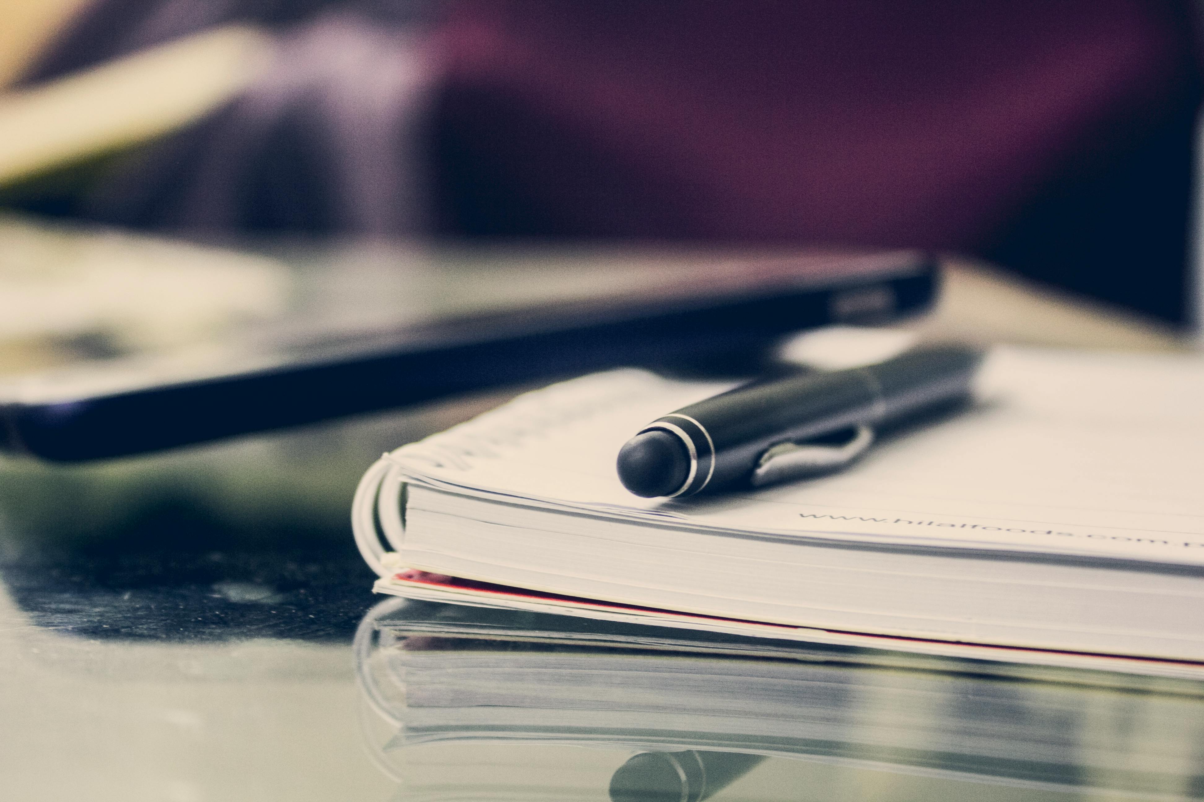 a pen on top of a stack of papers