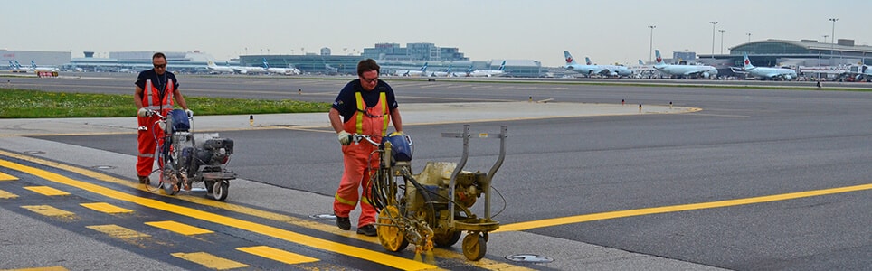Technicians painting lines on the runway at Toronto Pearson Airport.