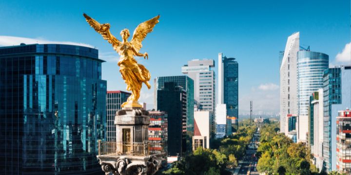 a golden statue in front of a city