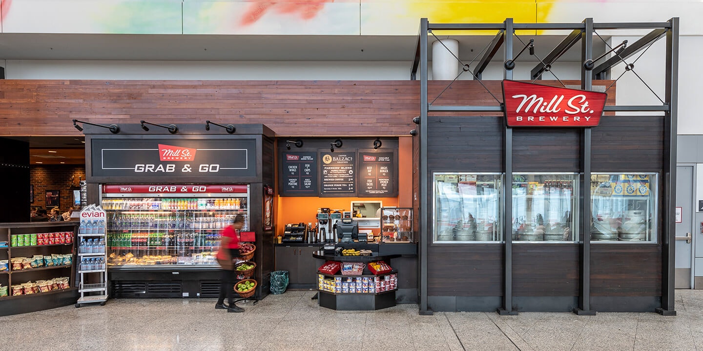 View of Mill Street take-out area with coffee station, grab-and-go fridge and snack displays