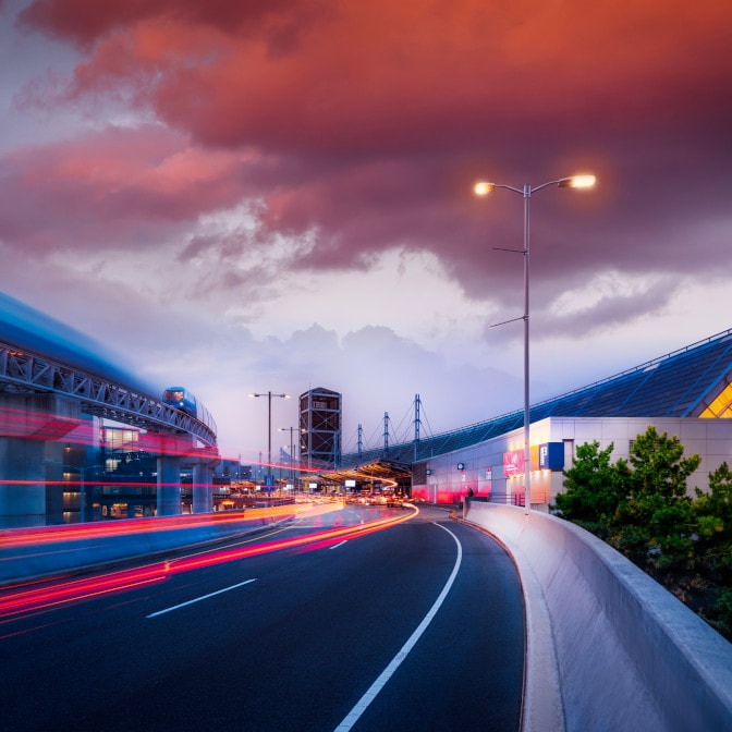 a road with a bridge and buildings on the side