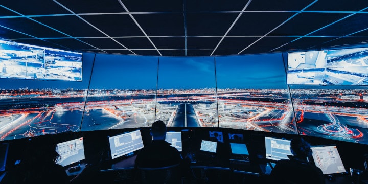 a room with many screens and people sitting in it